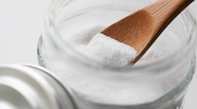 スプーンですくった重曹をトイレに入れる 